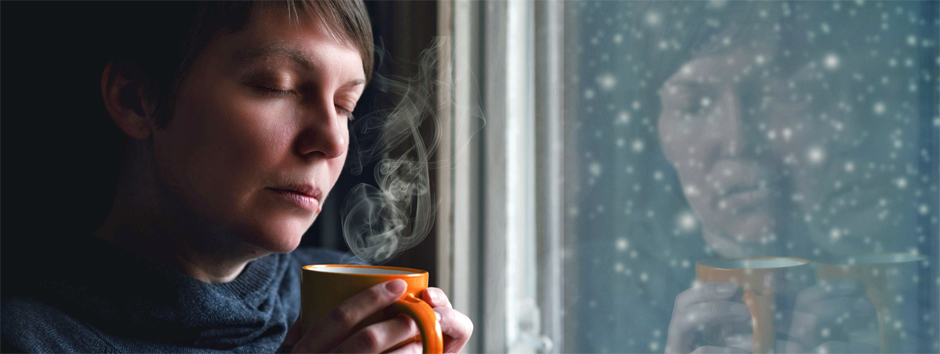 Frau in besinnlicher Stimmung am Fenster